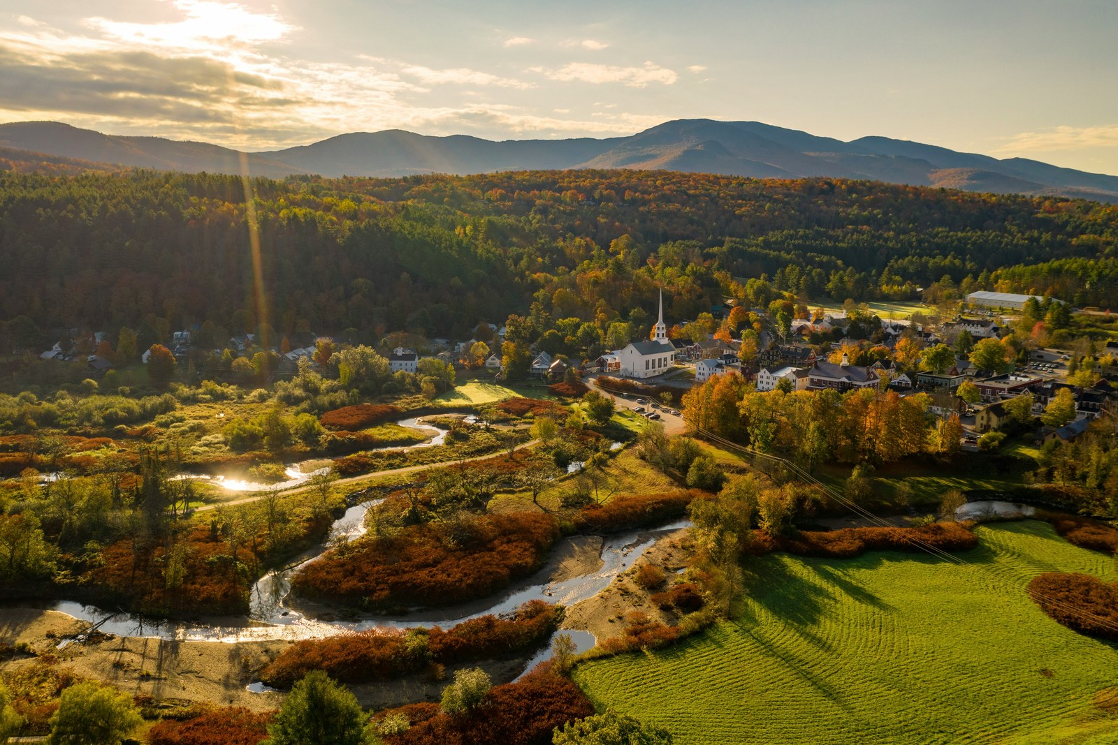 Aerial of Stowe village, the white Community Church, and Mount Mansfield in autumn