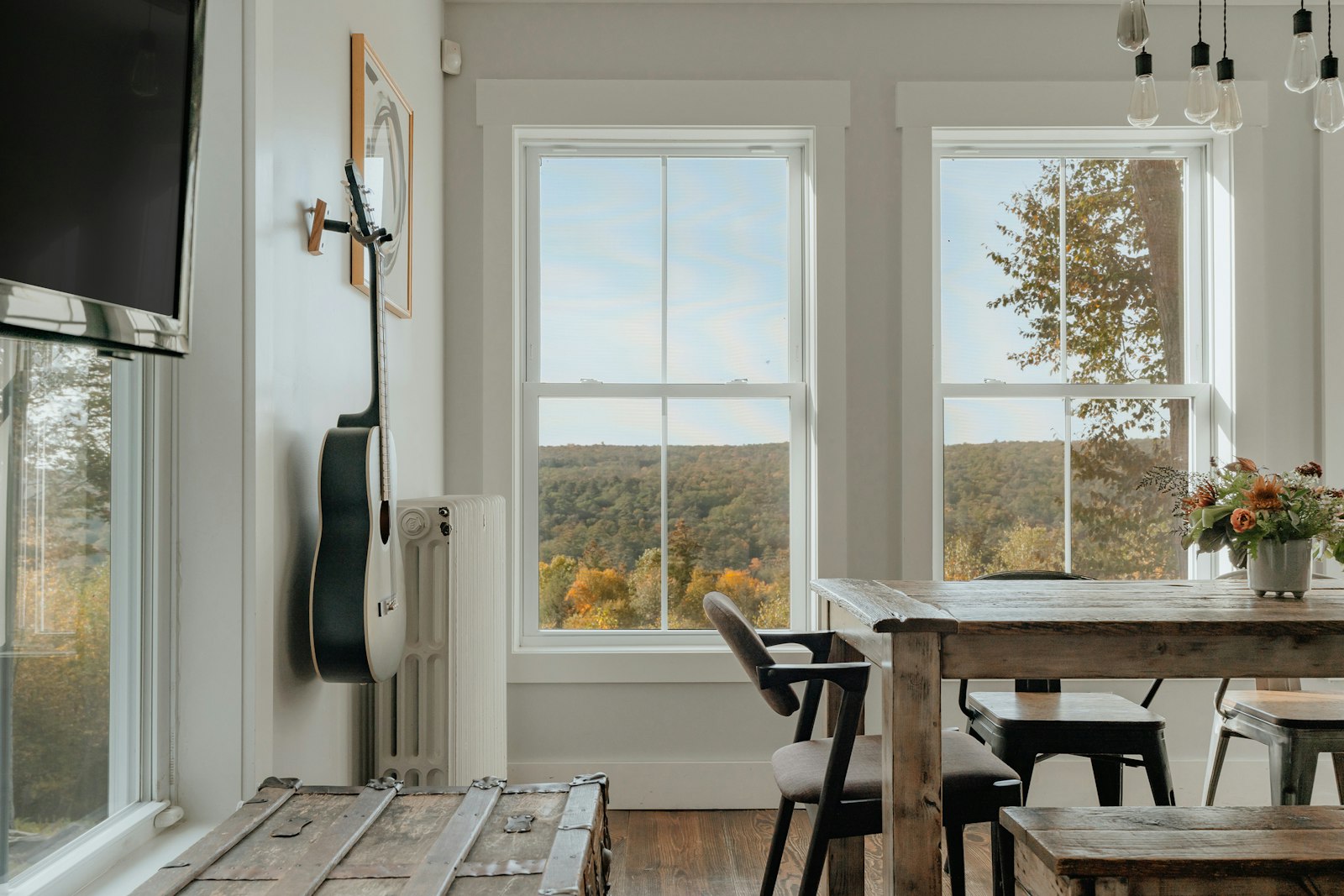 Rental dining room with a wood table and windows over the trees