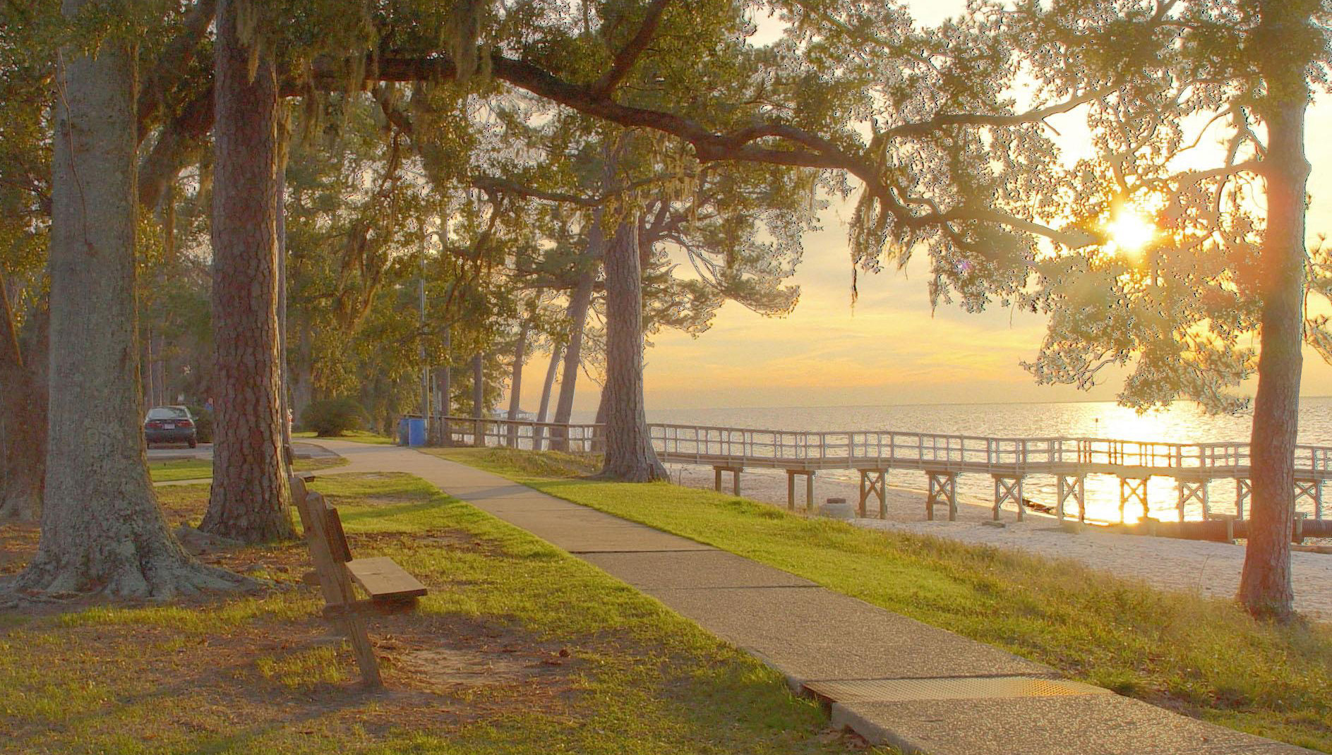 Oak-lined Fairhope bay walk and pier at sunset