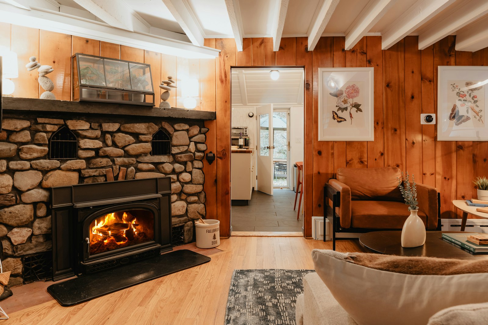 Wood-paneled cabin living room with a stone fireplace