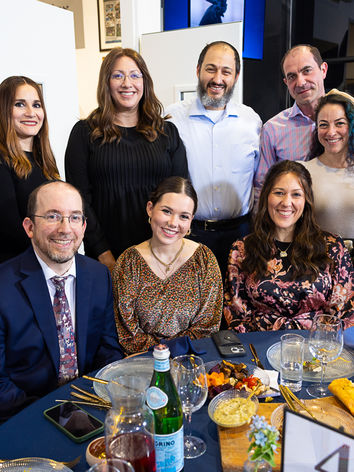Patronage event guests smiling at a formal dinner table.
