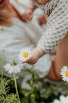 Nærbillede af babyhånd i blomstermark