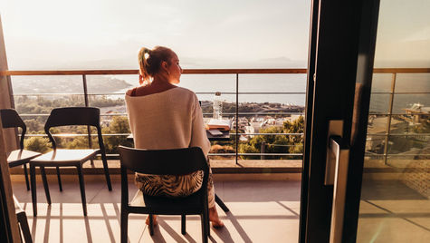 A girl sitting on a chair in a balcony