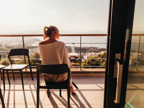 A girl sitting on a chair in a balcony