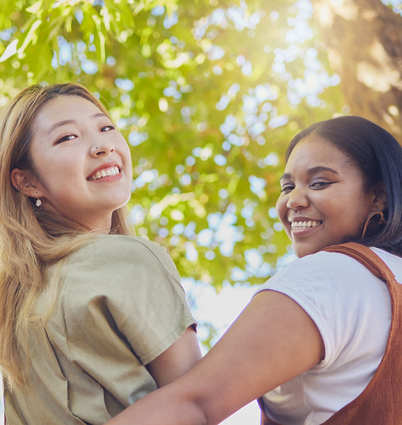 two women looking over their shoulders and smiling