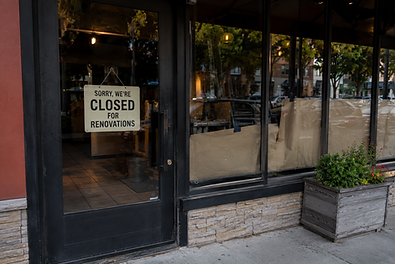 Picture of a front door of a retail store with a sign that says 'sorry we are closed for renovations'