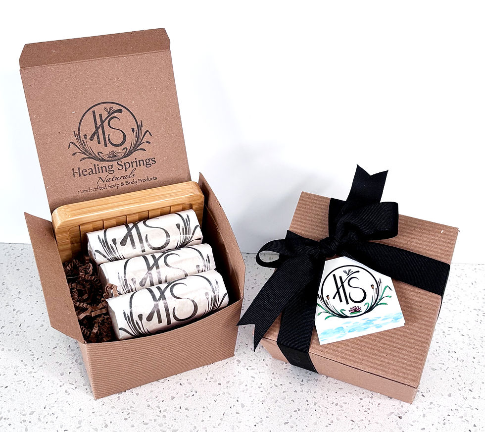Thumbnail: One open gift box containing wrapped soap and soap dish alongside one closed gift box tied with black ribbon and gift tag.