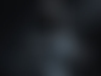 Black perfume bottles on stacked gray blocks, spotlighted against a dark background, creating a