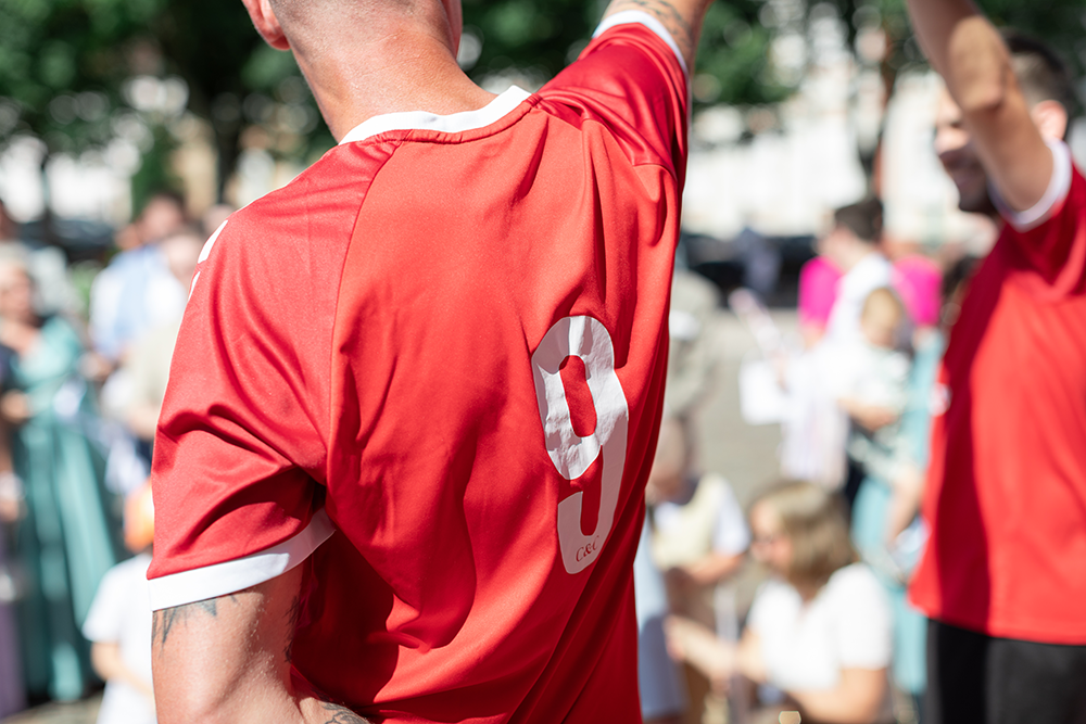 joeur de foot tient ballon en l'air pour la haie d'honneur des mariés
