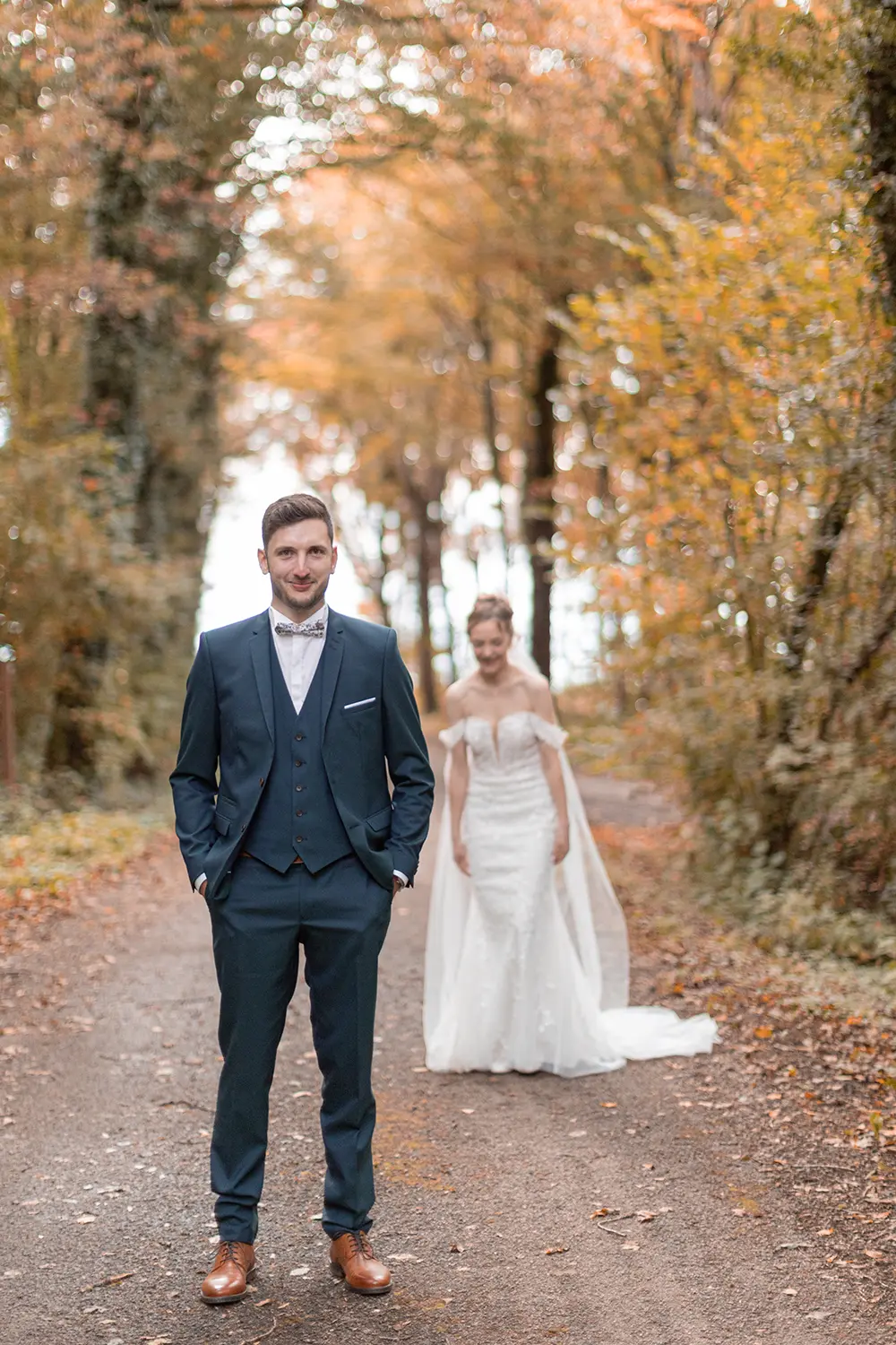 Le marié sourit en attendant sa future femme dans le forêt d'Haguenau en automne pour leur first loo