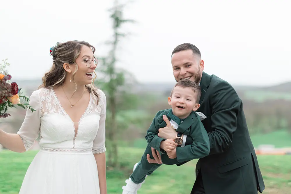 Le marié fait faire l'avion à son fils et la mariée les regarde