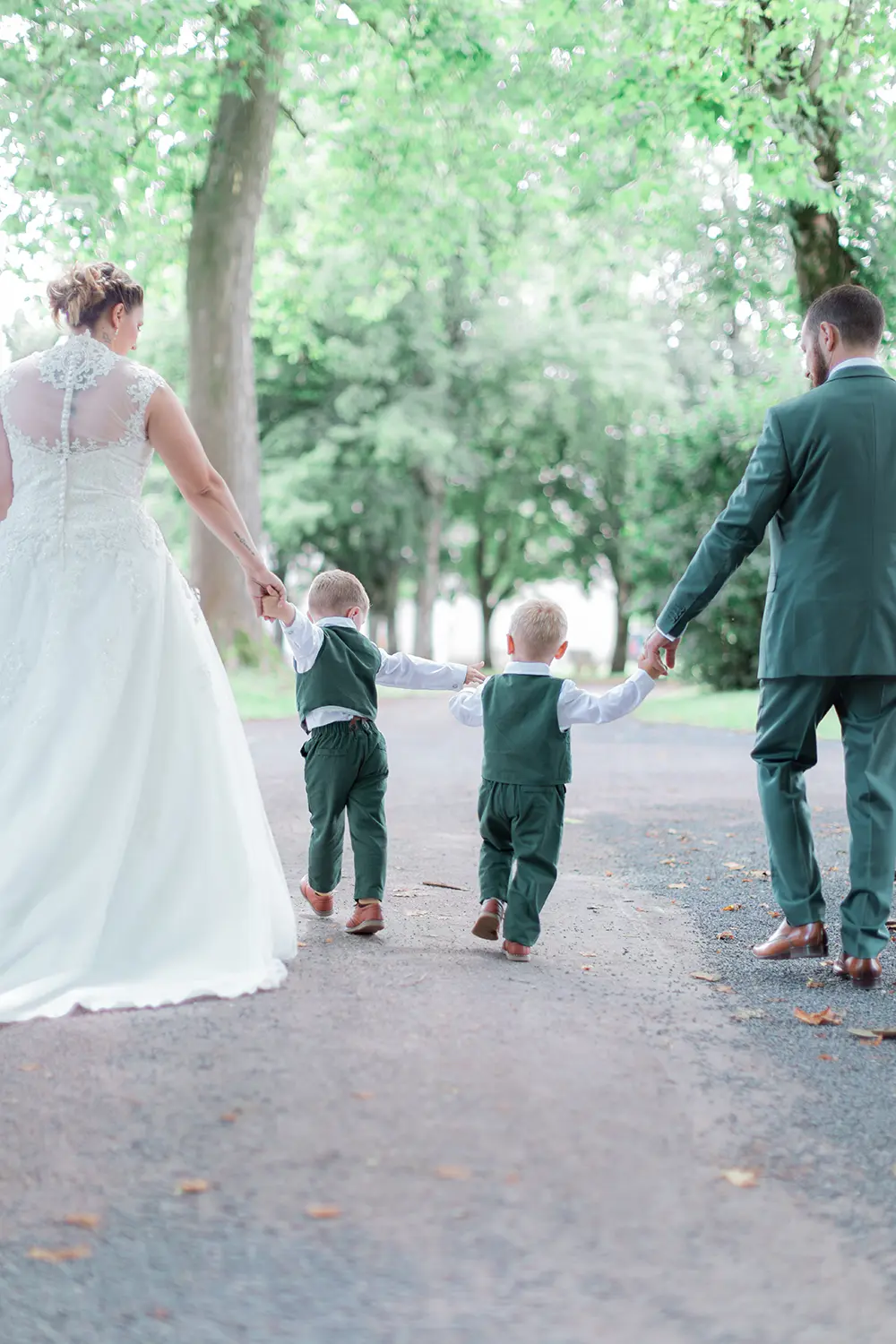 Les mariés se tiennent la main avec leurs deux enfants lors de leur first look