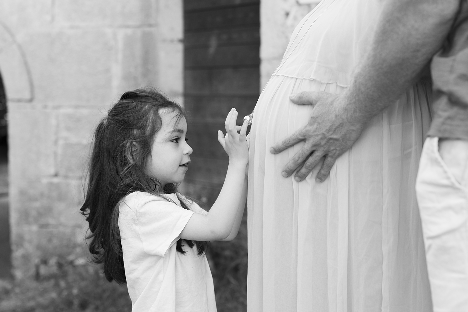 Eva, la grande soeur, qui joue avec le bola sur le ventre arrondi de sa maman