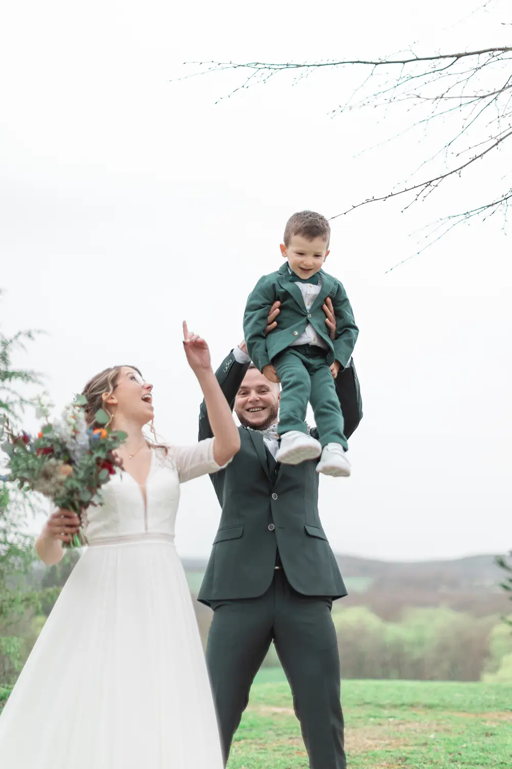 Les mariés jouent et rigolent avec leur fils lors de leur first look