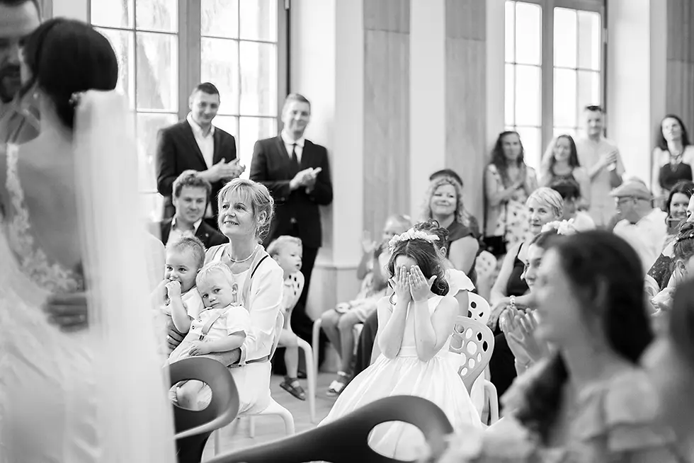 La fille cadette des mariés se cache les yeux pendant qu'ils s'embrassent à la mairie d'Haguenau