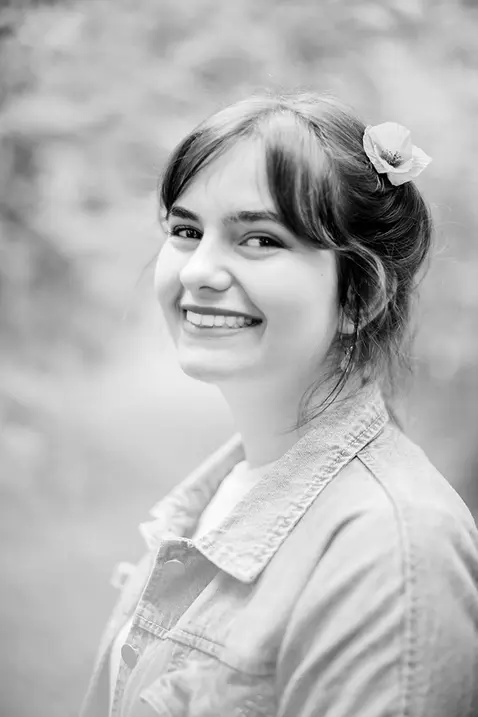 Portrait de comédienne dans la forêt de Langres : Jeune femme souriante, regardant l'objectif avec confiance et charme. Photographe Lifestyle Portrait Langres. 