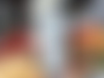 A glass of vodka surrounded by grains, cherries, apples, maple syrup, ginseng, and a Holstein cow.