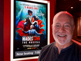 Michael Stevens in front of the movie for "Hadestown" limited movie release.