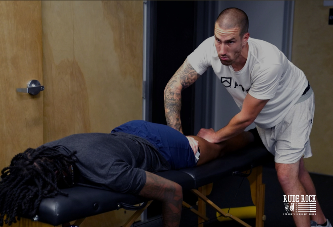 Coaching working on athlete's hamstring.