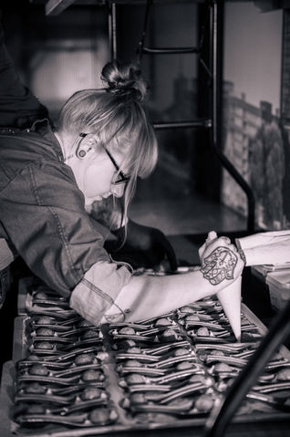 KochFabrik Köchin beim Verzieren der Speisen
