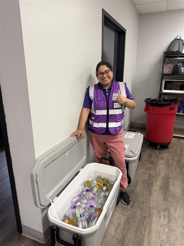 Infinity staff member, Diana, handing out water and Propel drinks to employees.