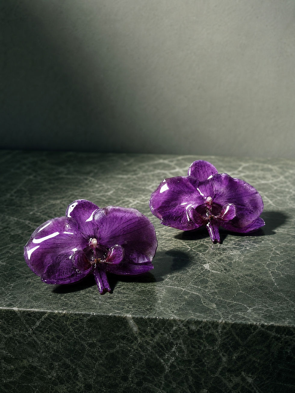 big real purple orchid flower earrings on bride model with pulled back hair shows her back open back dress. vancouver local