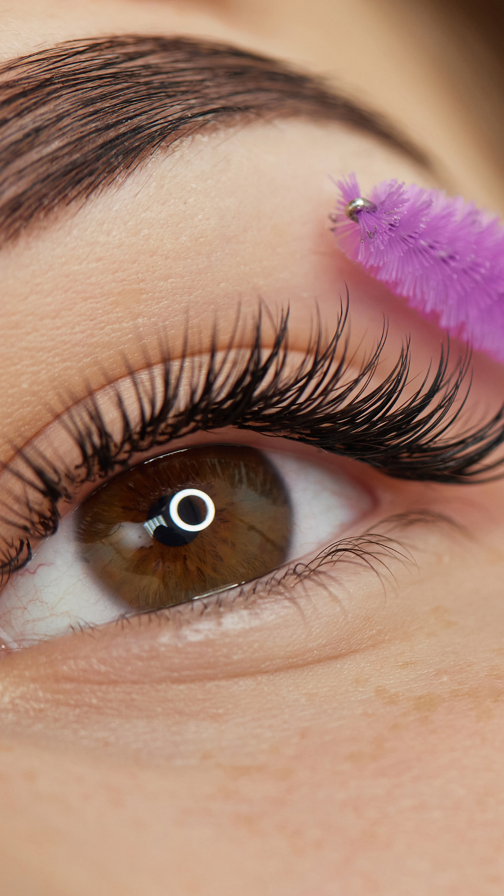 Nahaufnahme eines grünen Auges mit langen Wimpern, Blick nach oben.