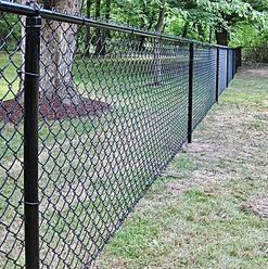 Black chain link fence surrounding residential backyard.
