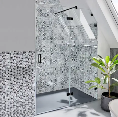 Transparente Glas-Duschabtrennung in einer Nische mit dekorativen, blau gemusterten Fliesen im Hintergrund – individuelle Badplanung von BAD ELEMENTE.