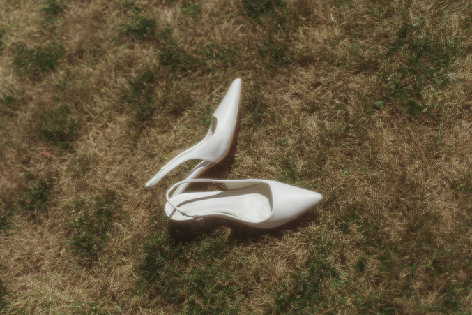 Brides high heel wedding shoes laying on the grass 