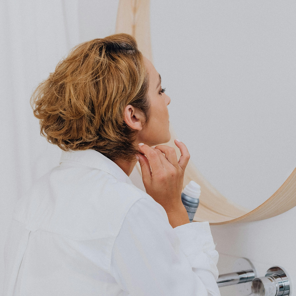 Midlife woman looking thoughtfully at herself in a mirror