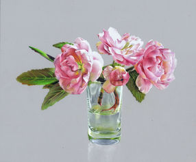 three pink blossoms in a drinking glass