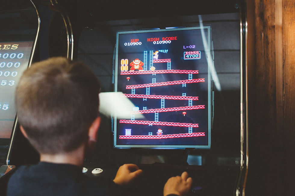Kid playing Donkey Kong on an Arcade