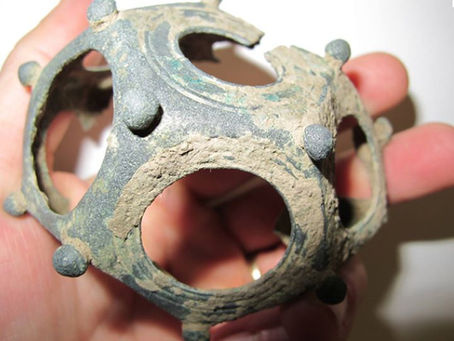Photographie d'un dodécaèdre gallo-romain en bronze ajouré et bouleté, un objet mystérieux dont la fonction reste une énigme pour les archéologues.