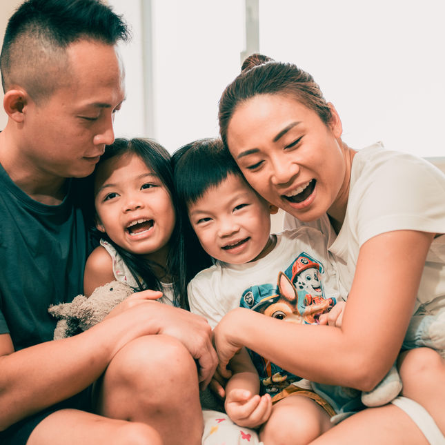 a family is sitting on a couch and one of the children is wearing a paw patrol shirt