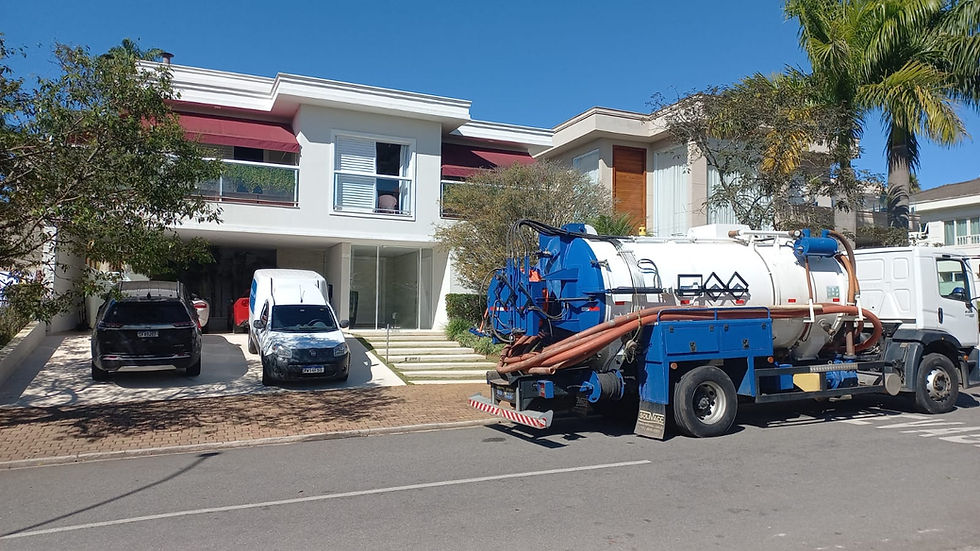 Caminhão limpa fossa parado em frente a uma casa