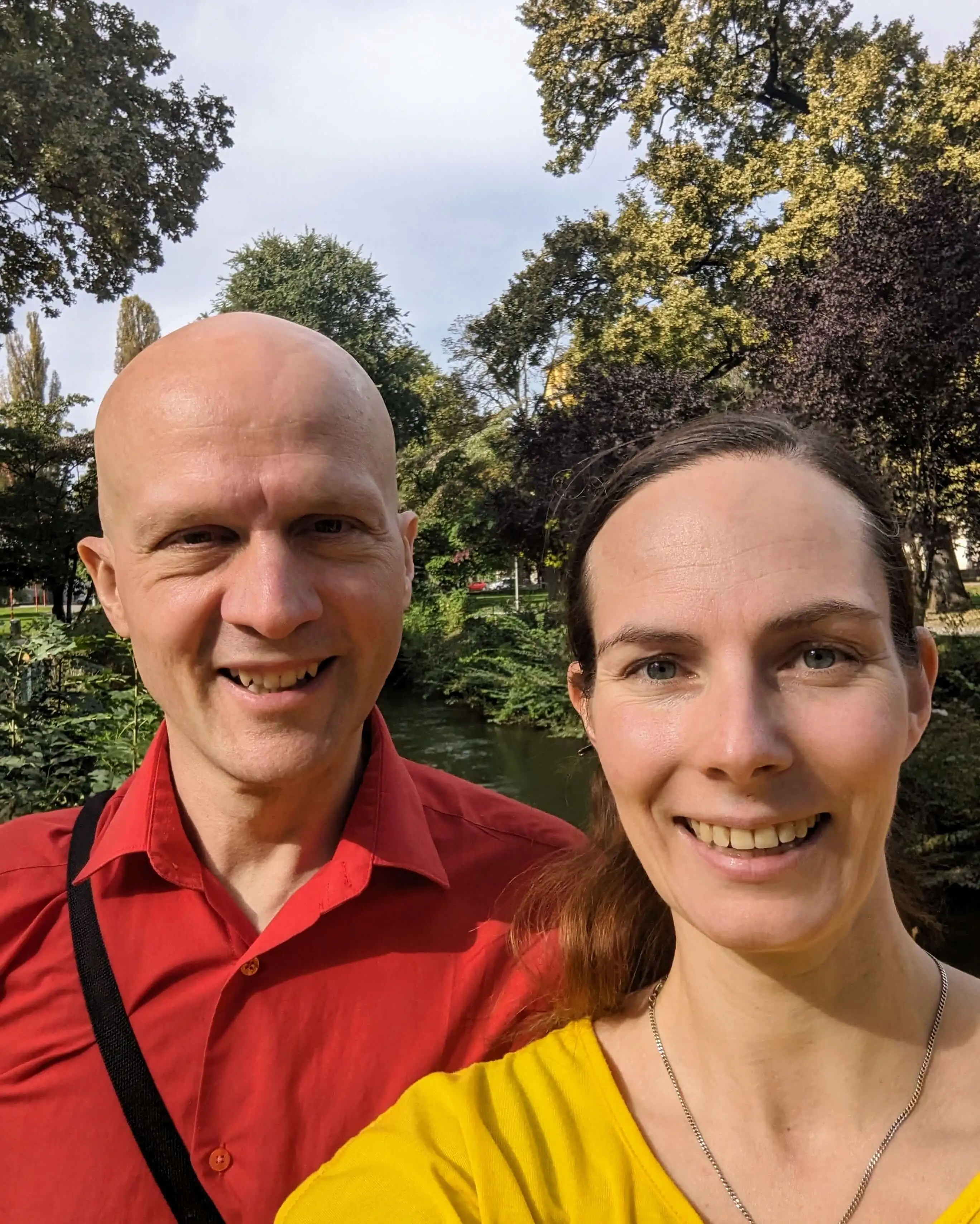 Sandor und Conny strahlen in die Kamera und stehen in einem Park