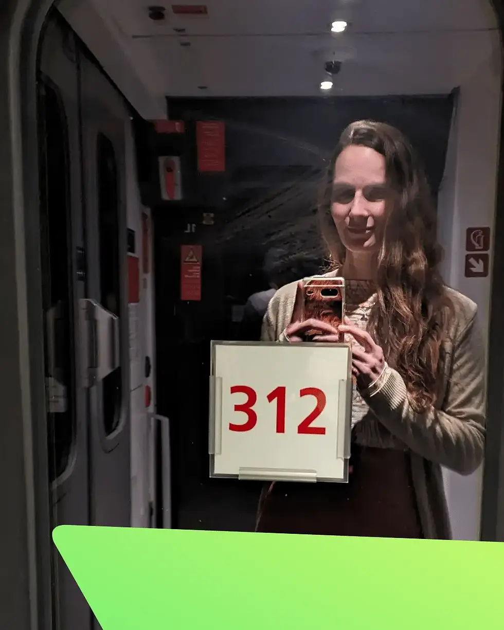 Conny mit Handy und ihrem Spiegelbild von einer Zugtüre