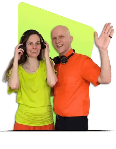 Auf diesem Bild sind Sandor und Conny zu sehen, beide tragen Kopfhörer und lächeln in die Kamera. Conny trägt ein leuchtend gelbes Top und Sandor ein oranges Hemd. Ihre entspannte Körperhaltung und die Kopfhörer deuten auf eine angenehme, musikalisch inspirierte Arbeitsumgebung hin.