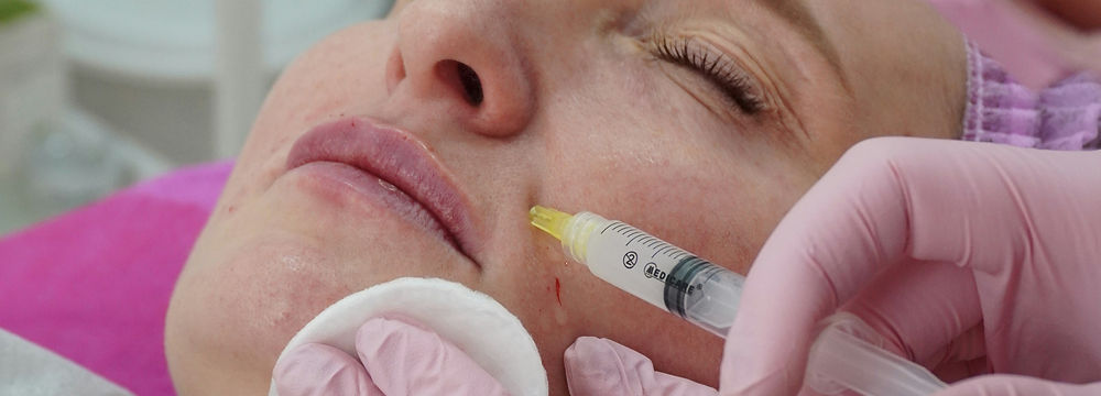 Aesthetic practitioner administering skin booster treatment to client