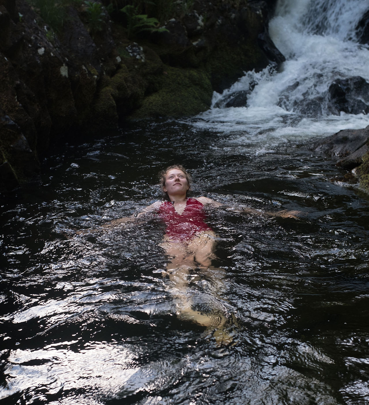 Wild swimming in a waterfall on the East Okement river, Dartmoor