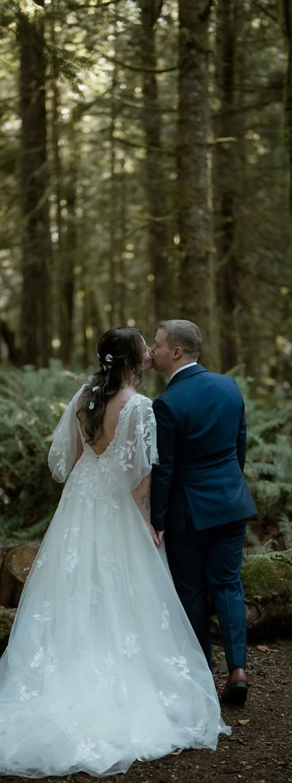 bride and groom kissing at rainforest ceremony