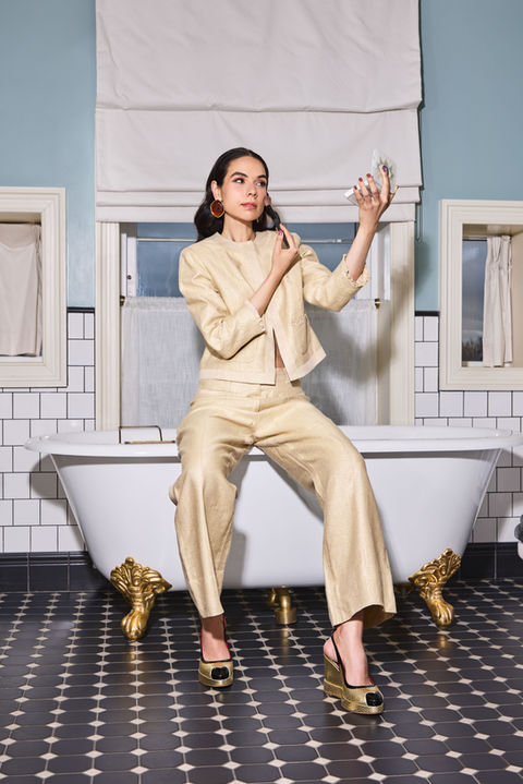 model in beige suit in bathroom setting