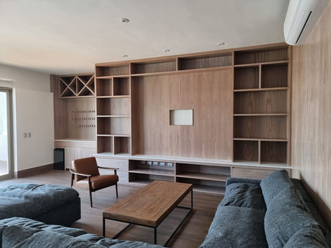 mueble de television en sala principal con bar y librero de madera.jpeg