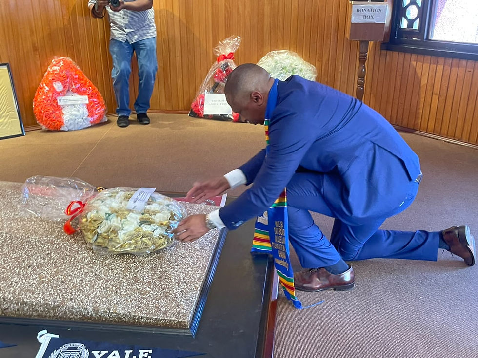 Secretary Mosley kneels to place a wreath at the WEB Dubois Masoleum during his tript to GHana.