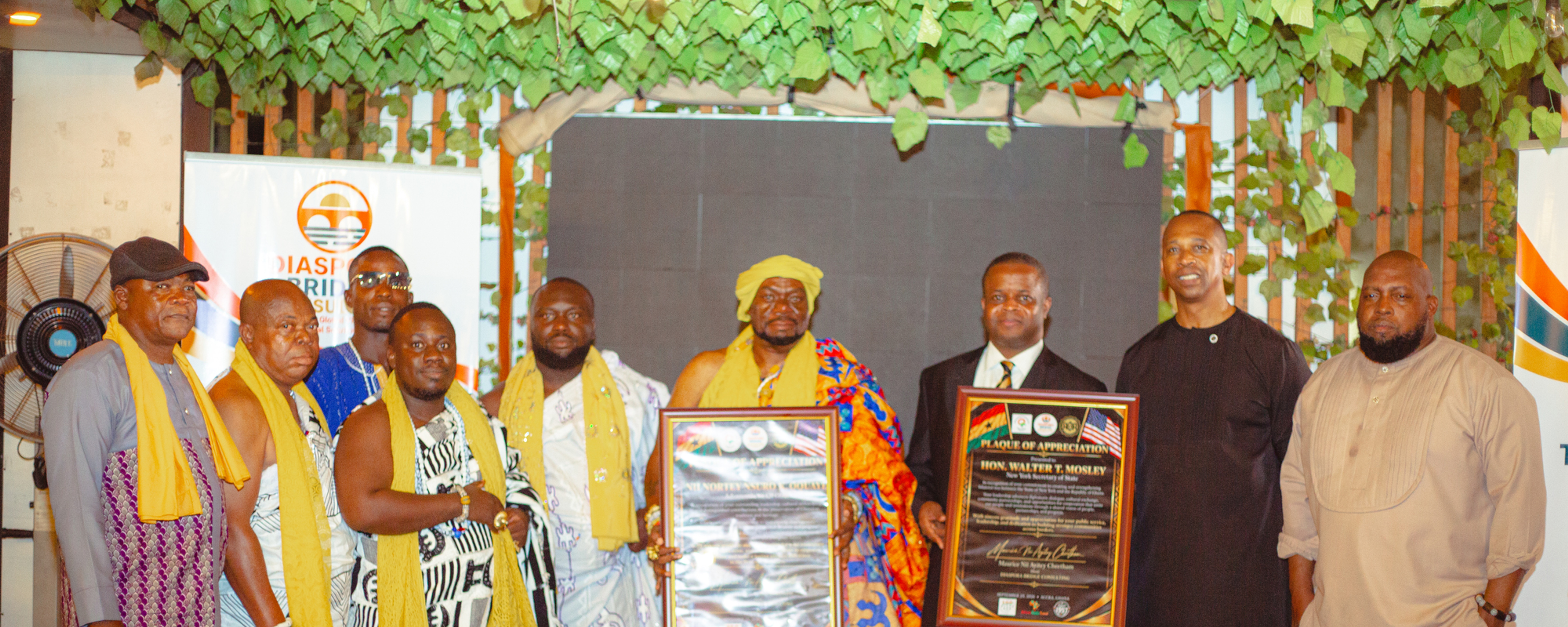 Nii Nortey Qoquaye, the Osu Youth King, receives an award from New York State Secretary Walter T. Mosley while standing with members of the Osu Traditional Council in Accra, Ghana at the Diaspora Bridge Consulting Meet & Greet with Maurice Cheetham