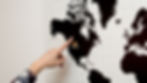 Woman pointing at North America on a world map