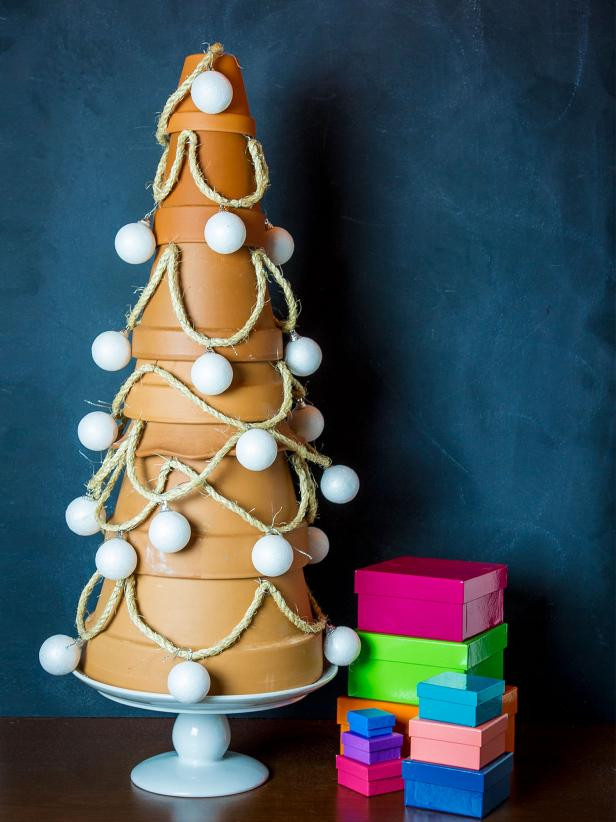 A small Christmas tree made of large, medium, and small terracotta pots stacked upside down and wrapped in string and Christmas ornaments.