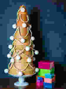 A small Christmas tree made of large, medium, and small terracotta pots stacked upside down and wrapped in string and Christmas ornaments.