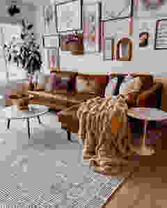 brown sofa with large sherpa blanket and cross-hatch rug